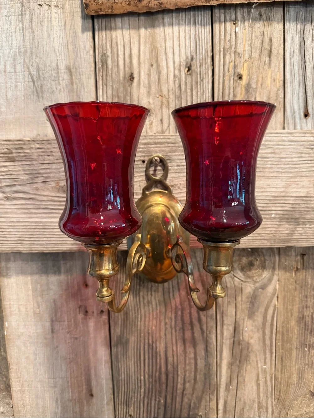 Vintage double-arm brass wall sconce fitted with ruby red votive cups